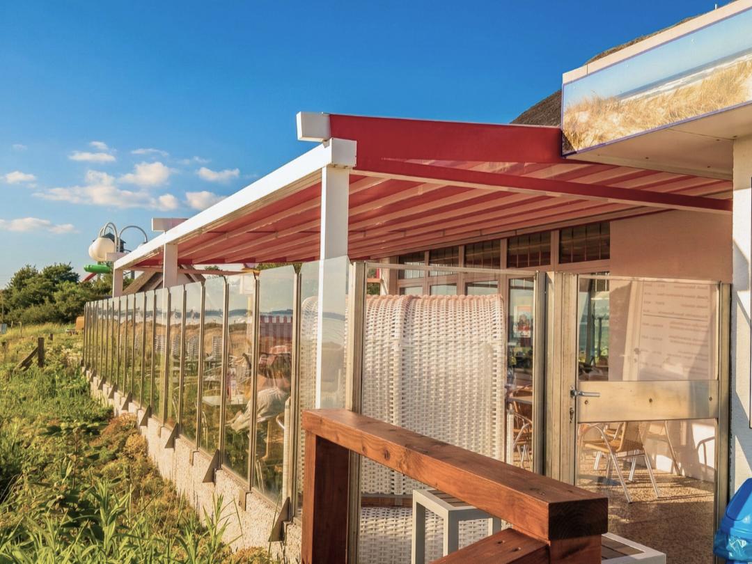 Pergoladach in Scharbeutz beim Restaurant Grillmeister, in Rot mit weißem Aluträgergestell an der Küste, am Strand - pefekte Gastro-Dach für Sonnen- und Regenschutz, Projekt Zschimmer